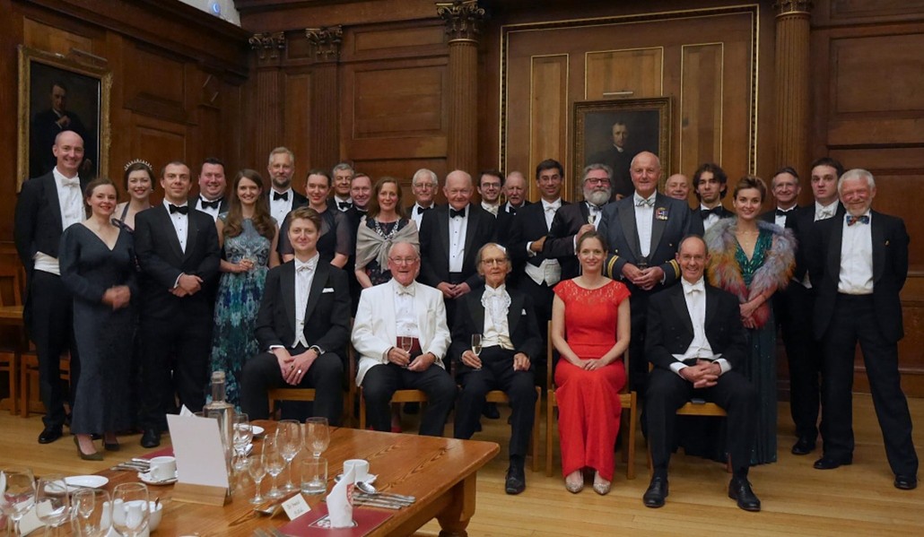 CURA members and alumni gathered in a wood-panelled room after a formal dinner